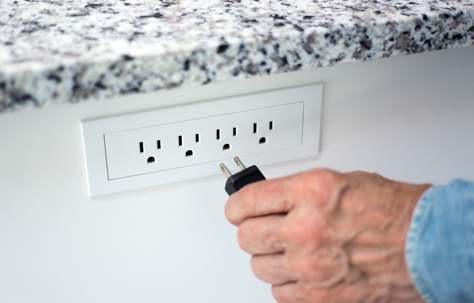 Man's Hand Putting Plug into Socket